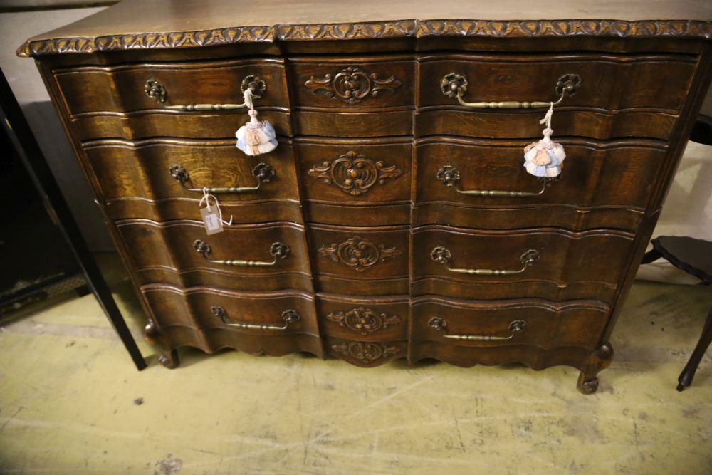 A 20th century French oak commode, fitted four long drawers with carved decoration, width 122cm, depth 43cm, height 92cm